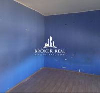 A room in a family house with blue walls and a floor with a wooden decor.