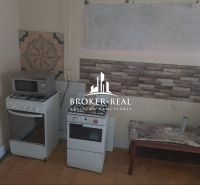A kitchen in a family house with a gas stove, microwave, and decorative tiles on the wall.