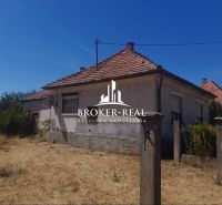 A family house in Csobád with plastered walls, a tiled roof, and neglected surroundings.