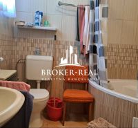 A bathroom in a family house with a bathtub, a sink, and colorful towels.