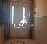 Entrance hall in a family house with a cabinet, floral decoration, and white doors.