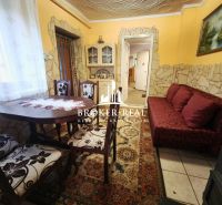 Dining room in a family house with a decorative table and a red sofa.
