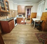 A kitchen in a family house with wooden decor, cabinets, and a dining area.