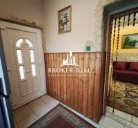 Entrance hall of a family house with light tiles and wooden paneling.