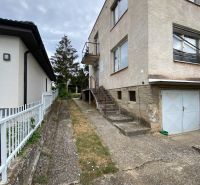 A family house on Zvončín Street in the town of Zvončín with a concrete sidewalk and a garage.
