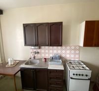 Kitchen in a family house with a sink, stove, and cabinets.