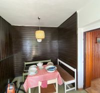 Interior of a family house with dark wood paneling and a dining area.
