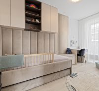 Children's room with a bed, desk, and wooden decor flooring in a 3-room apartment.