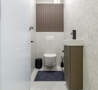 Elegant bathroom in a 3-room apartment with walls featuring a subtle pattern and a compact sink.