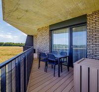 Sunny balcony with a view of the field in a 3-room apartment, brick cladding.
