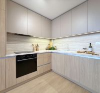 A kitchen in a 3-room apartment with a wooden decor floor and built-in appliances.