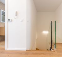 Family house with a hallway, staircase, wooden decor flooring, and a bathroom.
