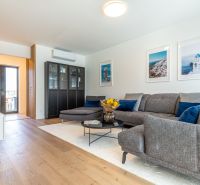 Living room in a family house with a wooden decor floor, a sofa, and decorative items.