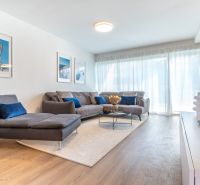 Living room in a family house with a sofa, paintings, and a wooden decor floor.