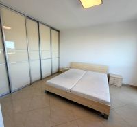 Bright bedroom with a sliding wardrobe, bed, and tiled floor in a studio apartment.