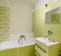 Green and white bathroom with a bathtub and a sink in a 3-room apartment.