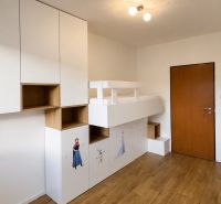Children's room with a bunk bed, storage space, and a floor with a wooden decor.