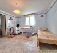 In the family house, there is a simple room with a kitchenette and an armchair.