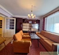 Living room in a family house with orange furniture and a display cabinet.