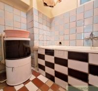 A bathroom in a family house with a sink and a bathtub, tiled.