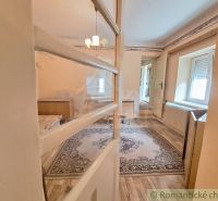 Interior of a family house with a wooden decor floor, carpet, and chandelier.