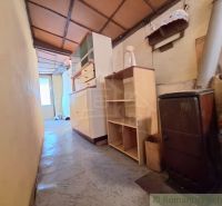 A narrow hallway in a family house with gas stoves, shelves, and a wardrobe.