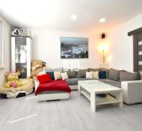 Living room in a 3-room apartment with a sofa, decorative pillows, and a wooden-patterned floor.