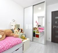 A children's room in a three-room apartment with a bed, plush toys, and a floor with a wooden decor.
