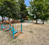 A children's playground in Topoľčany with various attractions and benches in the park.
