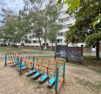 The exterior of the apartment building in Topoľčany with a children's playground and vegetation around the 1-bedroom apartment.