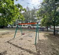 A playground with swings and greenery in the Topoľčany area near a 1-bedroom apartment.