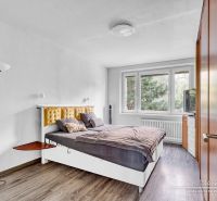 Bedroom with a bed and wooden decor flooring in a two-room apartment.