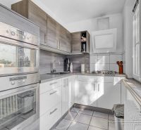 A kitchen with modern appliances and a window in a 2-room apartment.