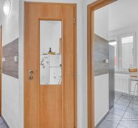 Interior of a 2-room apartment with wooden doors and a glass entrance to the kitchen.