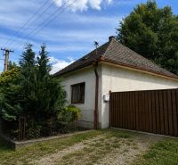 A family house in Urmince on Klačany Street, surrounded by trees and a fence.