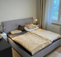A bedroom with a large bed, nightstands, and a wooden decor floor in a 3-room apartment.