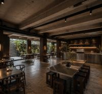 A space with metal tables and lighting, floor with wooden decor.