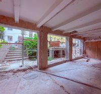 Renovation of commercial spaces with open walls and a view of stairs and greenery.