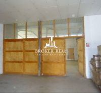 In warehouses and halls with wooden doors and pallets of products.