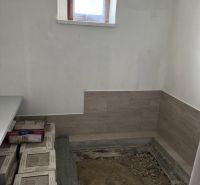 Interior of a family house with a window and sanded floor, preparation for tiling.