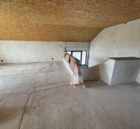 The attic of a family house with a wooden ceiling and a view of the interior staircase.