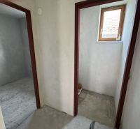 In the family house, there are two rooms with concrete floors and a small window.