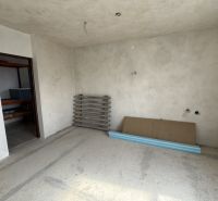 Interior of a family house with unfinished walls and floor, with materials on the floor.