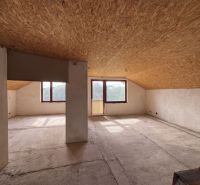 Attic space in a family house with large windows and a view.