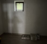 Attic room in a family house with boxes and a small window.