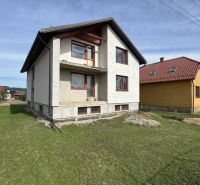 A family house in Plavnica with a green lawn and a partially finished facade.