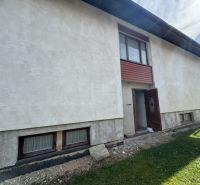 A family house in Plavnica with light plaster and wooden windows on the ground floor.