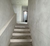 Concrete stairs leading to the upper floor in a family house with plastered walls.