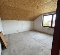 Attic room in a family house with a wooden ceiling and a large window.