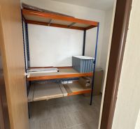 Storage space in a family house with a shelving unit and a floor with a wooden decor.